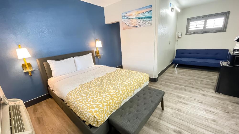 A hotel room with a bed, sofa, and window